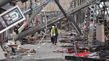 Varias personas caminan entre postes caídos por el terremoto de Año Nuevo, en la ciudad de Wajima (prefectura de Ishikawa), el 4 de enero.