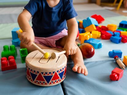 Un bebé juega con un tambor.