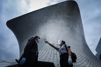 Una mujer toma la temperatura a los visitantes al museo Soumaya en la Ciudad de México