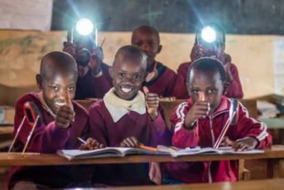 Niños con lámparas de d.light en la escuela.
