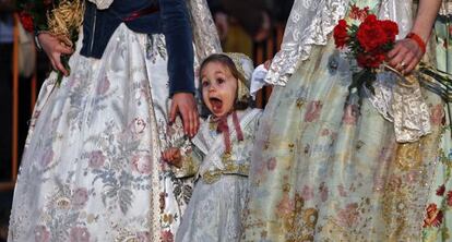 Una niña con el vestido de fallera, a su llegada a la plaza de la Virgen.