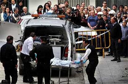 Los servicios funerarios retiran el cadáver de Jenny Lara Castillo de la vivienda de Alzira (Valencia) ante la presencia de vecinos.