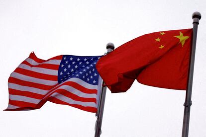 FILE PHOTO: Chinese and U.S. flags flutter outside the building of an American company in Beijing, China April 8, 2025. REUTERS/Tingshu Wang/File Photo