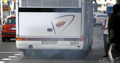 Un autocar expulsa gases por el tubo de escape circulando por el carril bus de la Gran V&iacute;a madrile&ntilde;a. 