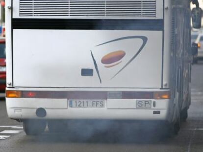 Un autocar expulsa gases por el tubo de escape circulando por el carril bus de la Gran V&iacute;a madrile&ntilde;a. 