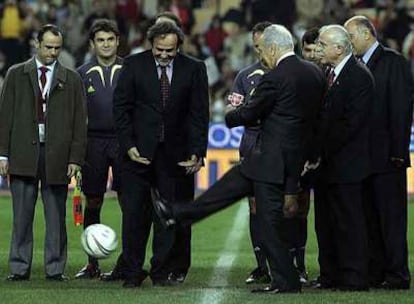 Platini, de frente en el centro, observa cómo Simon Peres realiza el saque de honor del partido.