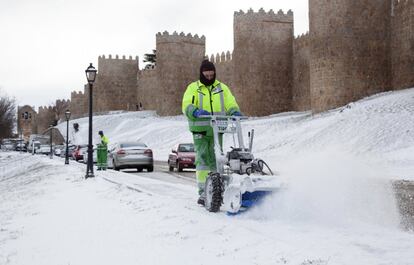 Un operario retira la nieve acumulada junto a la Muralla de Ávila, que hoy amenecía bajo un manto blanco.