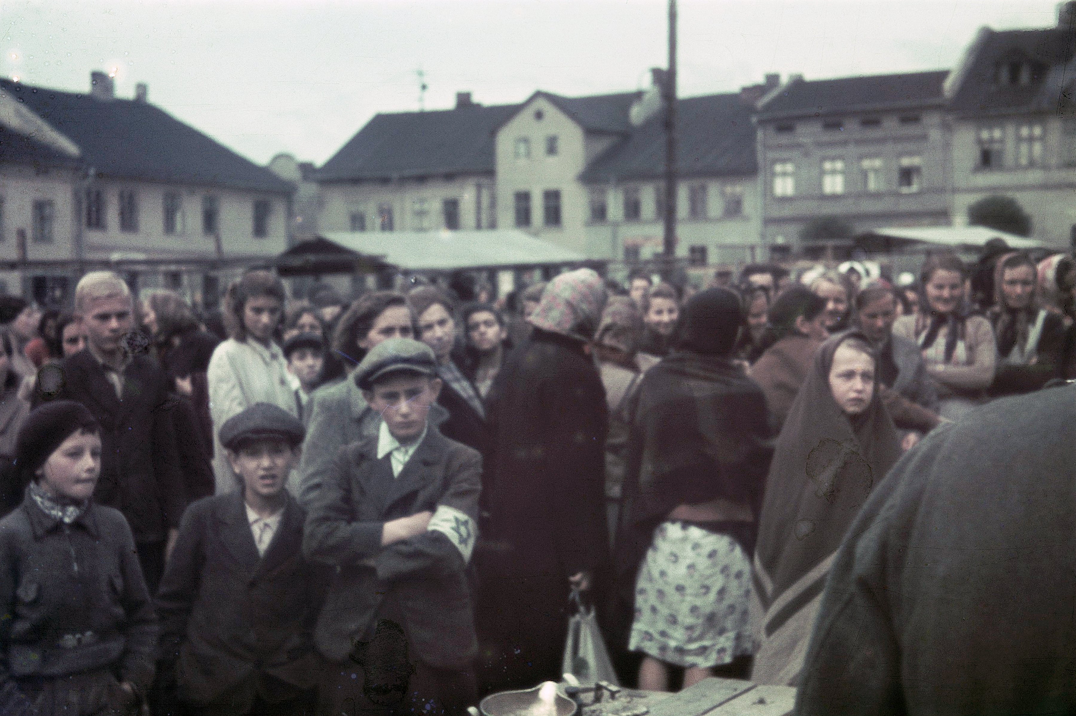 Ciudadanos judíos en la Plaza del Mercado Principal de Oświęcim. Algunos llevan el brazalete blanco con la estrella de David que eran obligados a portar para ser identificados.