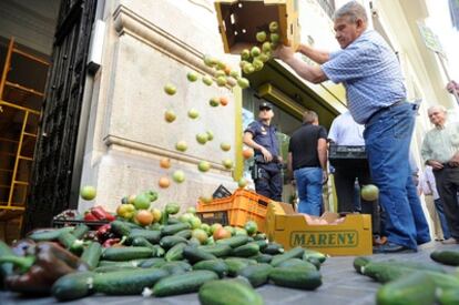 Un agricultor arroja frutas y verduras frente a la sede del consulado alemán en Valencia.
