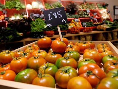 Una caja de tomates a la venta en un mercado.