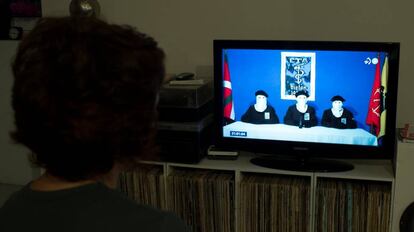 Una mujer mira un programa sobre el anuncio de disolución de ETA.