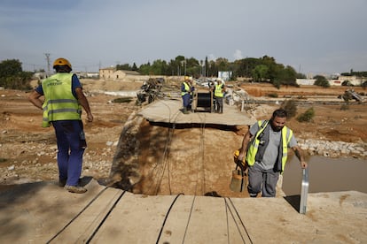 Los operarios lanzan fibra óptica sobre el puente dañado de Torrent.