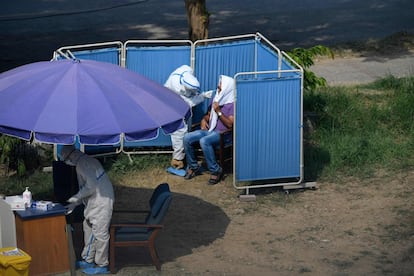 Un sanitario hace la prueba del coronavirus en una calle de Islamabad (Pakistán). Este país contabiliza ya 98.943 afectados y 2.002 muertes.