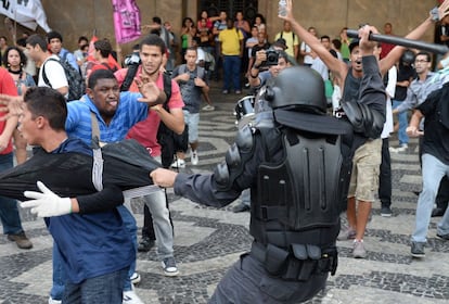Miembros del batallón de operaciones de policía especiales (BOPE) sostiene a un joven durante los enfrentamientos con manifestantes que entraron en la estación Central de tren en Río de Janeiro. El motivo del conflicto es la subida del precio del transporte público.