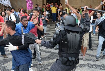 Miembros del batalln de operaciones de polica especiales (BOPE) sostiene a un joven durante los enfrentamientos con manifestantes que entraron en la estacin Central de tren en Ro de Janeiro. El motivo del conflicto es la subida del precio del transporte pblico.