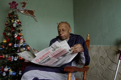 El disidente Guillermo Fariñas lee el <i>Gramma</i>, órgano del Partido Comunista cubano, ayer en su casa, en Santa Clara.