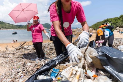 Tres de los más de 2.000 voluntarios que limpiaron una playa de Hong Kong el pasado 27 de mayo de este año.