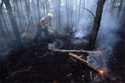 Miembros de los equipos de emergencias sofocan el fuego en la taiga siberiana.