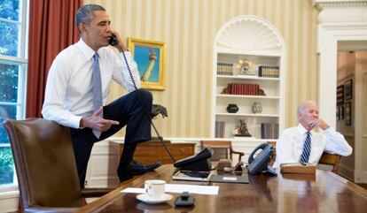 Barack Obama habla por teléfono ante la mirada del vicepresidente Joe Biden.