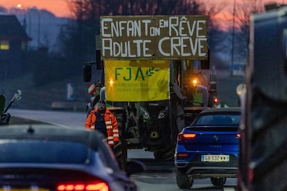 Un tractor participa en una protesta en la frontera de Bélgica y Francia, entre Aubange y Mont-Saint-Martin, con un cartel en el que se puede leer: "De niño sueñas con esto, de adulto mueres a causa de ello".