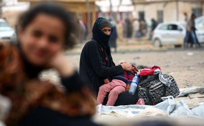 A displaced Syrian woman, who fled the countryside surrounding the Islamic State (IS) group stronghold of Raqa, sits at a temporary camp in the village of Ain Issa on April 28, 2017. / AFP PHOTO / DELIL SOULEIMAN