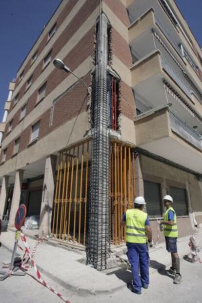 Obreros apuntalan un edificio en Lorca.