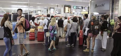 Varias personas hacen cola para comprar un billete de tren en las m&aacute;quinas expendedoras, en la estaci&oacute;n de Chamart&iacute;n, en Madrid.