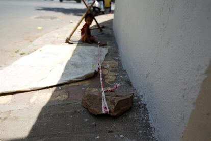 Barrier tape is tied around 15-month-old Shivani's ankle to prevent her from running away, while her mother Sarta Kalara works at a construction site nearby, in Ahmedabad, India, April 19, 2016. Kalara says she has no option but to tether her daughter Shivani to a stone despite her crying, while she and her husband work for 250 rupees ($3.8) each a shift digging holes for electricity cables in the city of Ahmedabad. There are about 40 million construction workers in India, at least one in five of them women, and the majority poor migrants who shift from site to site, building infrastructure for India's booming cities. Across the country it is not uncommon to see young children rolling in the sand and mud as their parents carry bricks or dig for new roads or luxury houses. REUTERS/Amit Dave       SEARCH "TIED TODDLER" FOR THIS STORY. SEARCH "THE WIDER IMAGE" FOR ALL STORIES