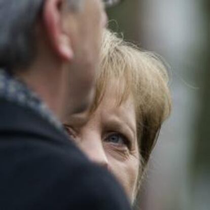 Angela Merkel mira a Juncker en una visita del presidente del Eurogrupo a Alemania.