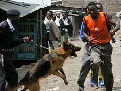 Un policía keniano y unos presuntos delincuentes, en la operación contra una secta criminal ayer en Nairobi.