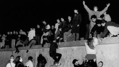 Centenares de personas escalan el Muro de Berlín, en Brandemburgo, celebrando la apertura de las fronteras alemanas.