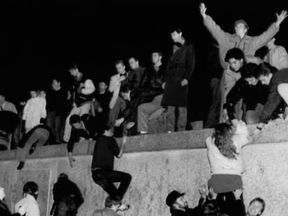 Centenares de personas escalan el Muro de Berlín, en Brandemburgo, celebrando la apertura de las fronteras alemanas.