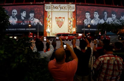 Aficionados fotografían el autobús del Sevilla FC a su llegada al estadio Sánchez-Pizjuán.