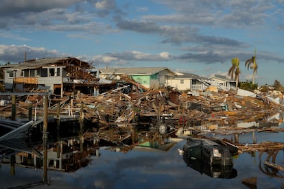 Cars and debris from washed away homes line a canal in Fort Myers Beach, Fla