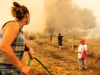 Varios vecinos intenta apagar el incendio en Cualedro (Ourense), ese lunes.