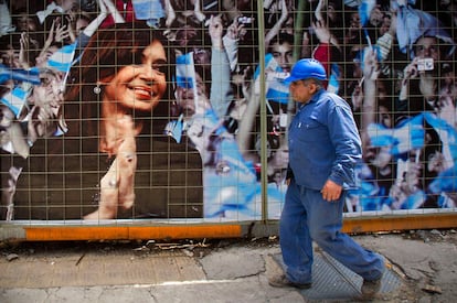 Un obrero de la construcción camina frente a un cartel electoral de Cristina Fernández en Buenas Aires.