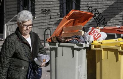 Una mujer pasa ante un cubo de basura este martes. 