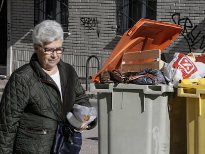 Una mujer pasa ante un cubo de basura este martes. 
