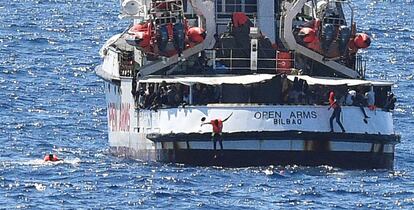 Varias personas saltan al mar desde el 'Open Arms', este martes cerca de la costa de Lampedusa (Italia).