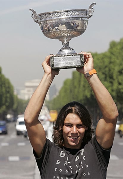 Nadal, con el Arco del Triunfo al fondo, alza el trofeo de Roland Garros.