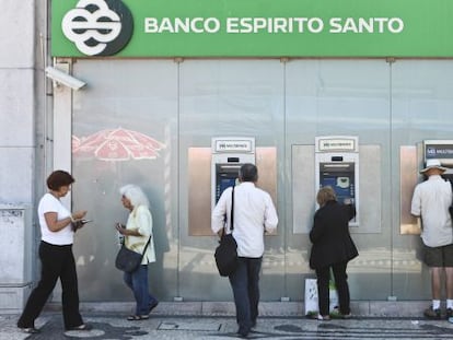 Varias personas retiran dinero de una oficina del BES en Lisboa.