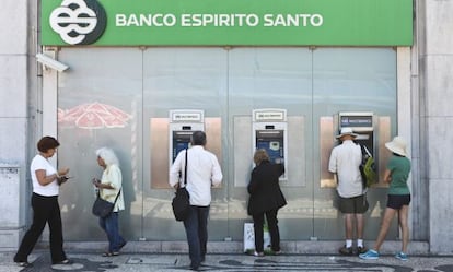 Varias personas retiran dinero de una oficina del BES en Lisboa.