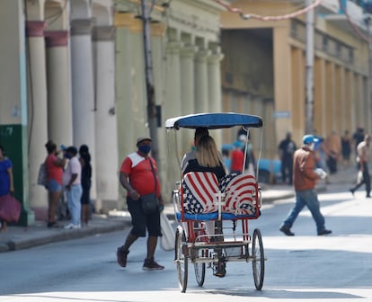 Un bicitaxi con los asientos tapizados con la bandera estadounidense transitando por La Habana (Cuba).