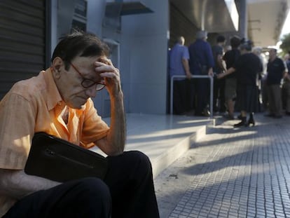 Aposentado grego descansa junto a agência bancária fechada. Muitos correntistas se aglomeravam nos bancos desde o começo da manhã.