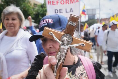 Una manifestante sostiene un crucifijo durante la marcha en Bogotá.