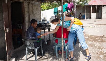 Dolores Puértolas saluda a una familia durante la construcción de un reservorio de agua en Azua, República Dominicana.