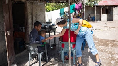Dolores Puértolas saluda a una familia durante la construcción de un reservorio de agua en Azua, República Dominicana.