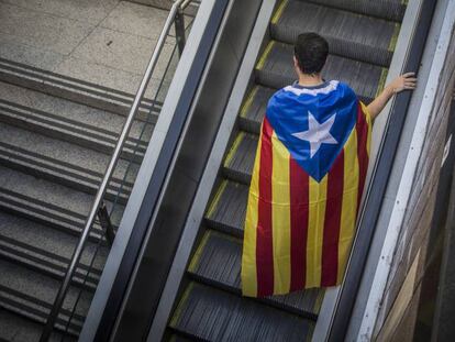 Un hombre sale de la estaci&oacute;n Plaza de Catalu&ntilde;a con una estelada durante la Diada del 11 de septiembre.