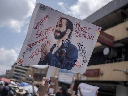 Un manifestante levanta una pancarta en contra del presidente de El Salvador, Nayib Bukele