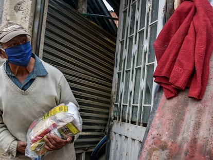 Un hombre de la tercera edad carga una despensa donada por el Ejército colombiano durante la pandemia de covid-19, en Bogotá.